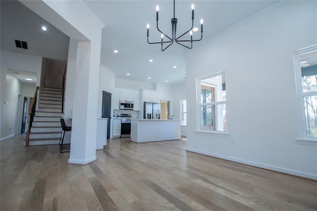 90 Ayers Rd, Bowdon, GA 30108 - unfurnished living room with light wood finished floors, a chandelier, stairs, crown molding, and recessed lighting