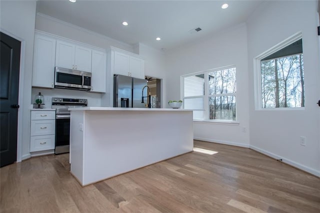 90 Ayers Rd, Bowdon, GA 30108 - kitchen featuring stainless steel appliances, light wood-style floors, white cabinetry, recessed lighting, and a kitchen island with sink