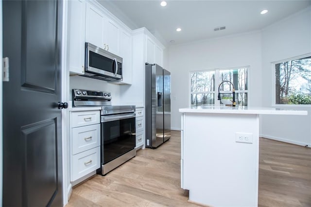 90 Ayers Rd, Bowdon, GA 30108 - kitchen featuring appliances with stainless steel finishes, light wood-style floors, white cabinetry, an island with sink, and recessed lighting