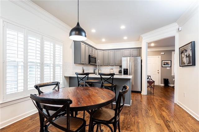 dining space with a wealth of natural light, dark wood-style flooring, and baseboards