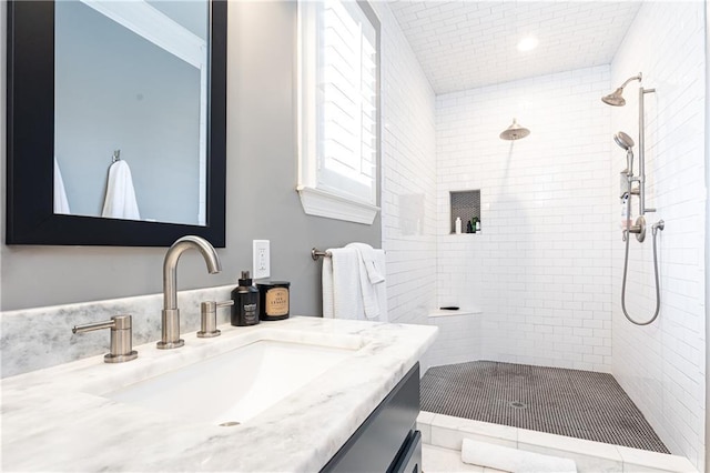 full bath featuring tiled shower and vanity