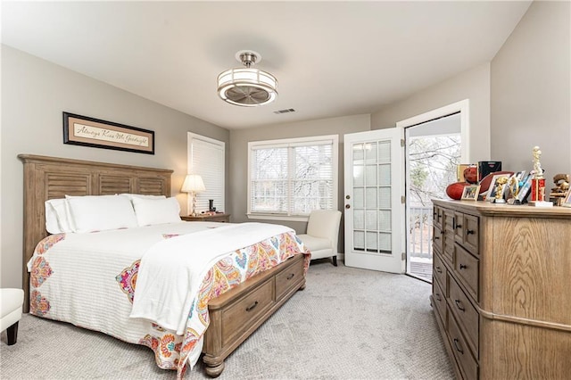 bedroom with access to exterior, light colored carpet, and visible vents