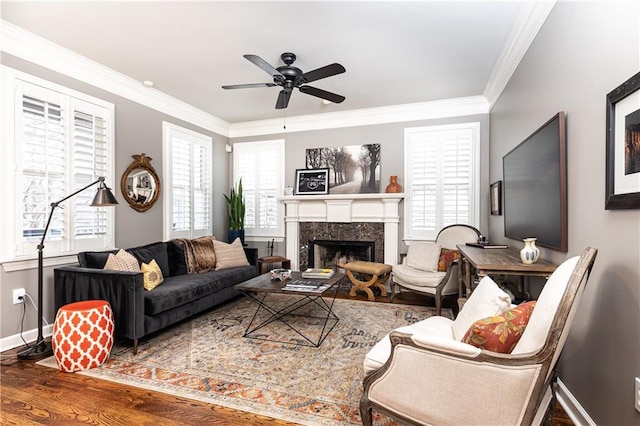 living area featuring a healthy amount of sunlight, crown molding, and wood finished floors