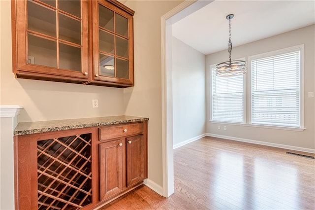 4404 Village Field Pl, Suwanee, GA 30024 - bar featuring light wood-style floors, decorative light fixtures, a chandelier, and baseboards