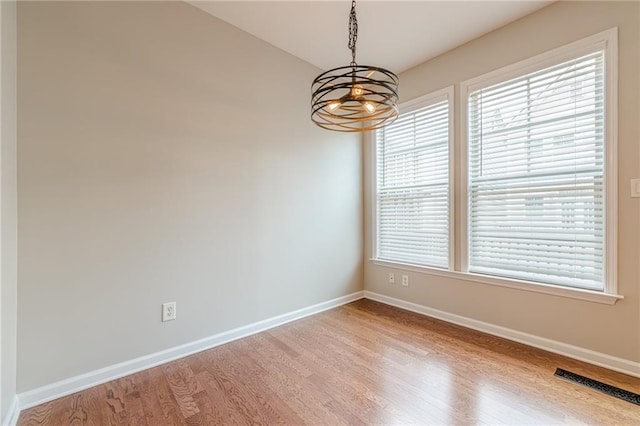 4404 Village Field Pl, Suwanee, GA 30024 - spare room featuring wood finished floors, a chandelier, and baseboards