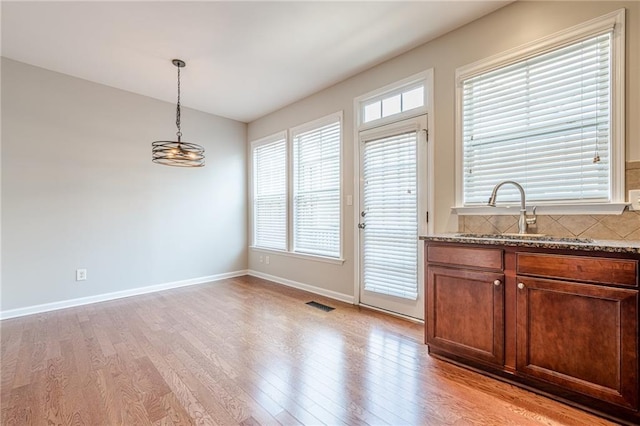 4404 Village Field Pl, Suwanee, GA 30024 - unfurnished dining area with a sink, light wood finished floors, a chandelier, baseboards, and plenty of natural light