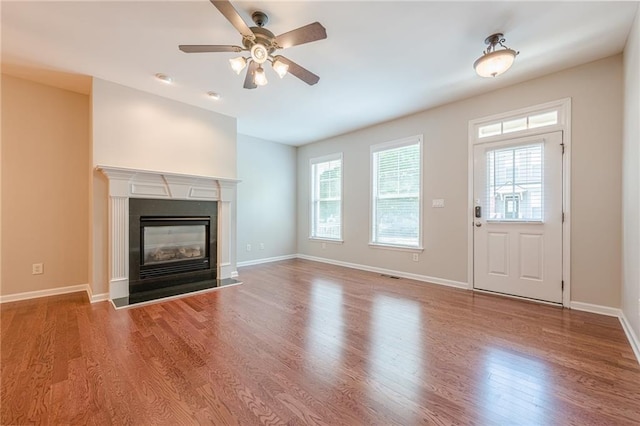 4404 Village Field Pl, Suwanee, GA 30024 - unfurnished living room with wood finished floors, ceiling fan, baseboards, and a fireplace with flush hearth