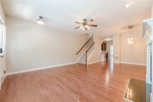 4404 Village Field Pl, Suwanee, GA 30024 - unfurnished living room with stairway, light wood-style flooring, a ceiling fan, and baseboards
