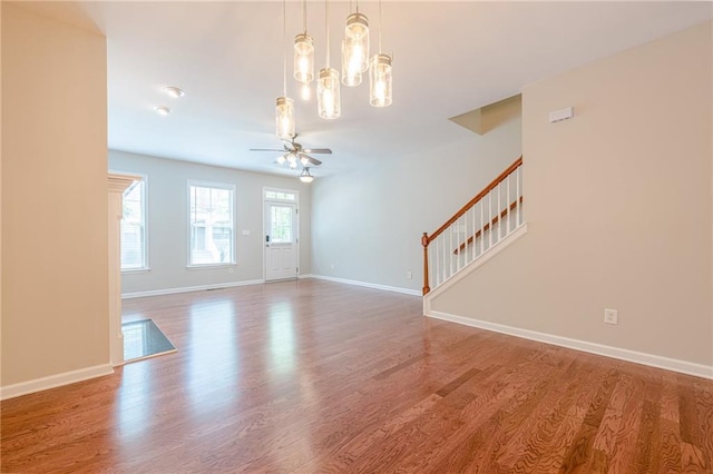 4404 Village Field Pl, Suwanee, GA 30024 - unfurnished living room featuring wood finished floors, stairway, a chandelier, ceiling fan, and baseboards