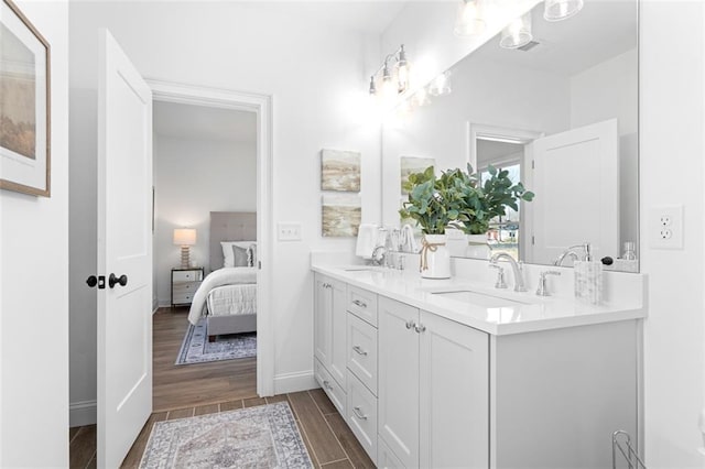 3317 Stillwood Ln, Hapeville, GA 30354 - ensuite bathroom with wood finish floors, double vanity, ensuite bathroom, a sink, and baseboards