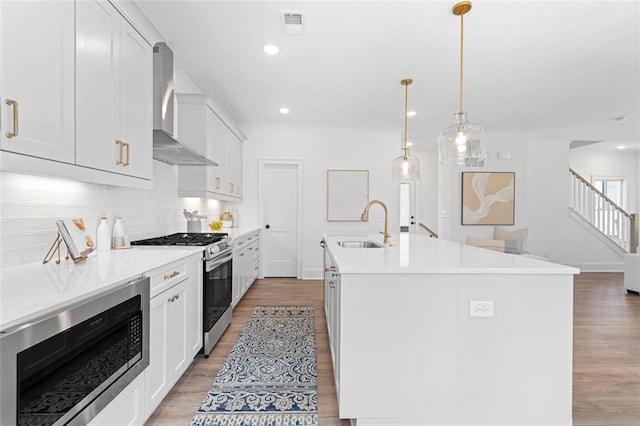 3317 Stillwood Ln, Hapeville, GA 30354 - kitchen featuring wall chimney exhaust hood, appliances with stainless steel finishes, light wood-style flooring, and a sink