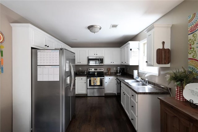 19 Autumn Pl NE, White, GA 30184 - kitchen with appliances with stainless steel finishes, dark countertops, white cabinets, and dark wood-style flooring