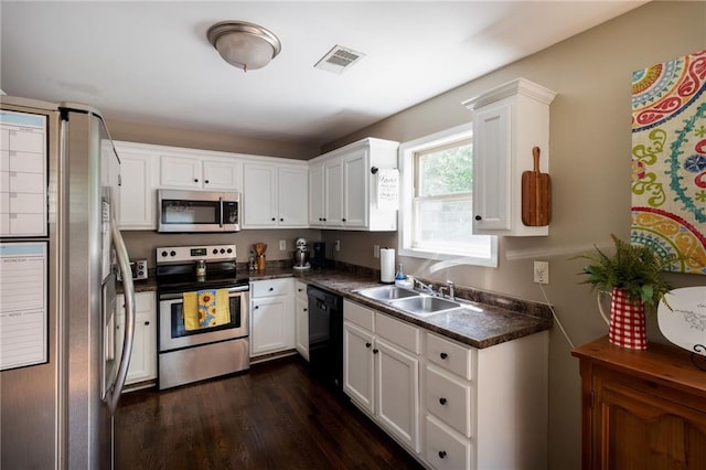 19 Autumn Pl NE, White, GA 30184 - kitchen with stainless steel appliances, dark countertops, white cabinetry, and dark wood finished floors