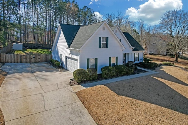 view of front of property with roof with shingles, driveway, and fence