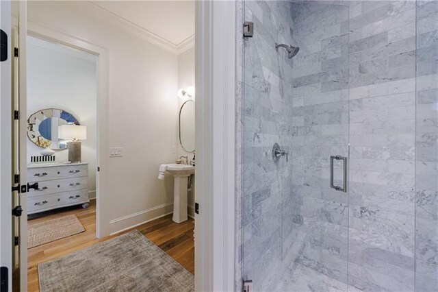 bathroom featuring crown molding, hardwood / wood-style floors, sink, and walk in shower