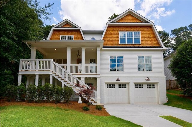 view of front of home featuring a porch, a garage, and a front lawn