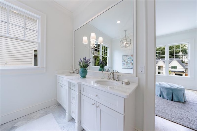 bathroom with a notable chandelier, vanity, and crown molding