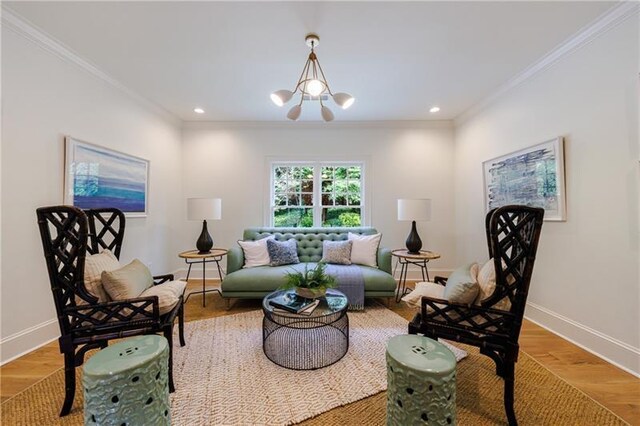 living room featuring wood-type flooring, ornamental molding, and a notable chandelier