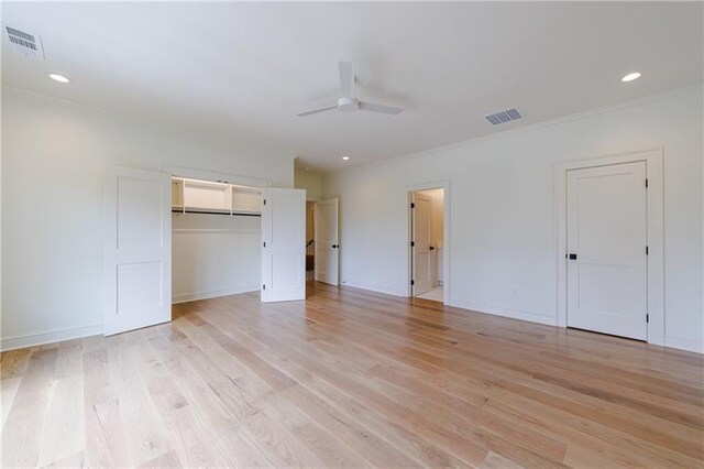 unfurnished bedroom with ceiling fan, a closet, crown molding, and light hardwood / wood-style flooring