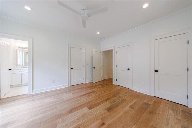 unfurnished bedroom featuring connected bathroom, ceiling fan, multiple closets, light wood-type flooring, and ornamental molding