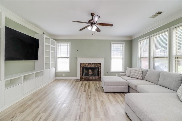 95 Jeffco Dr, Jefferson, GA 30549 - living area with light wood-type flooring, a ceiling fan, crown molding, a premium fireplace, and built in shelves