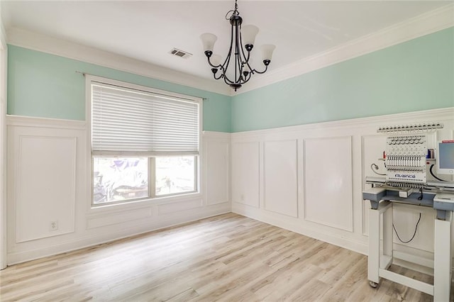 95 Jeffco Dr, Jefferson, GA 30549 - unfurnished dining area with a decorative wall, a chandelier, a wainscoted wall, ornamental molding, and light wood-type flooring