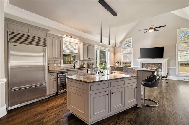 kitchen with wine cooler, a ceiling fan, lofted ceiling, built in fridge, and dark wood-type flooring