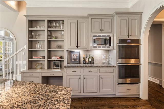 kitchen featuring arched walkways, appliances with stainless steel finishes, open shelves, and visible vents