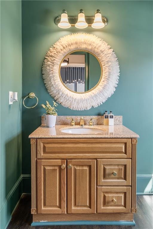 bathroom featuring baseboards, wood finished floors, and vanity