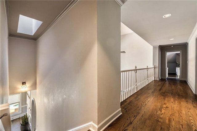 hall with baseboards, a skylight, crown molding, and wood finished floors