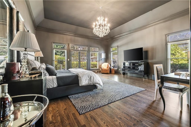 bedroom featuring a tray ceiling, wood finished floors, a chandelier, and crown molding