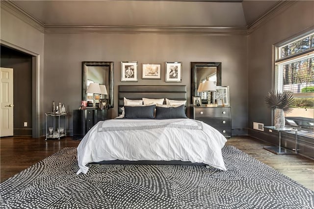bedroom with baseboards, wood finished floors, and crown molding