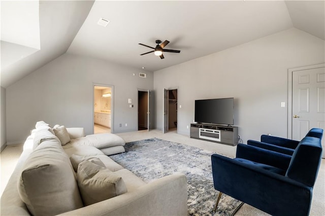 living area with ceiling fan, visible vents, vaulted ceiling, and light carpet
