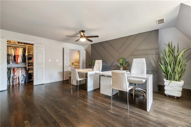 office space with dark wood-style flooring, visible vents, an accent wall, a ceiling fan, and vaulted ceiling