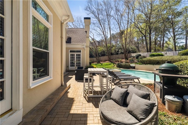 view of patio / terrace with a fenced in pool, a fenced backyard, and french doors