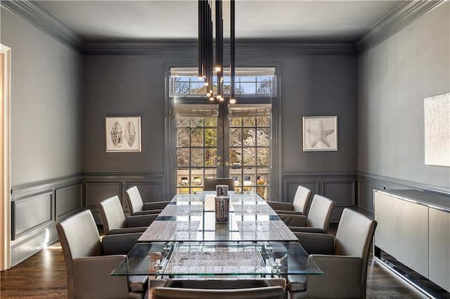 dining space featuring crown molding, a decorative wall, and french doors