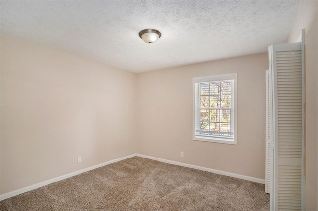 unfurnished bedroom featuring carpet floors, a textured ceiling, and baseboards