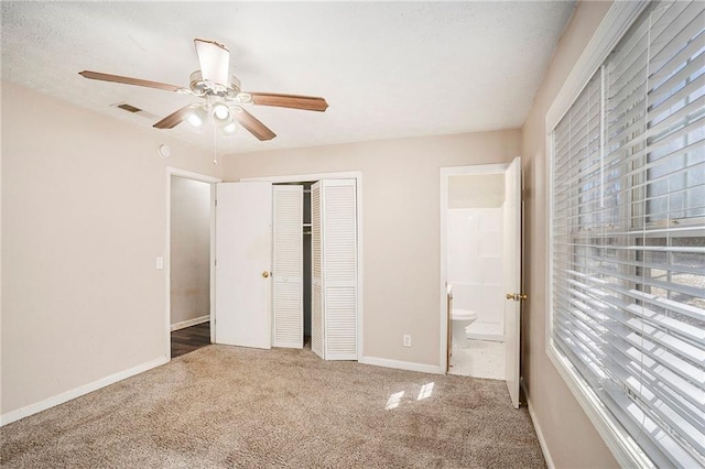 unfurnished bedroom featuring carpet, a closet, visible vents, connected bathroom, and baseboards