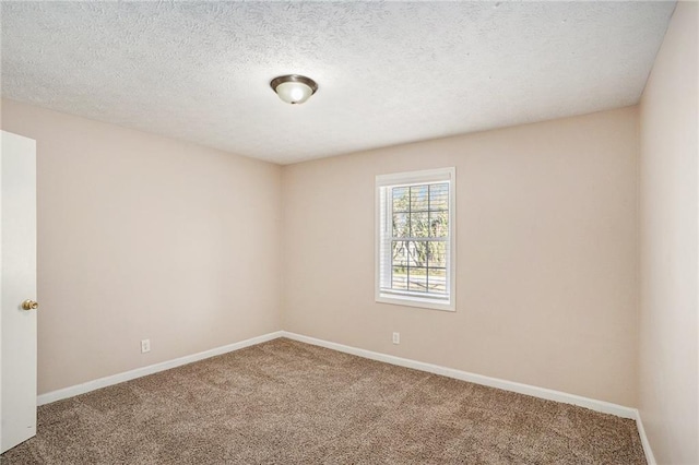 spare room with carpet, a textured ceiling, and baseboards