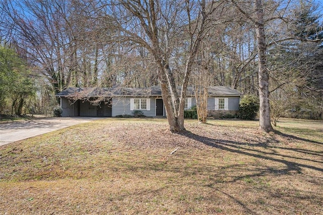 ranch-style home with a carport, concrete driveway, and a front lawn