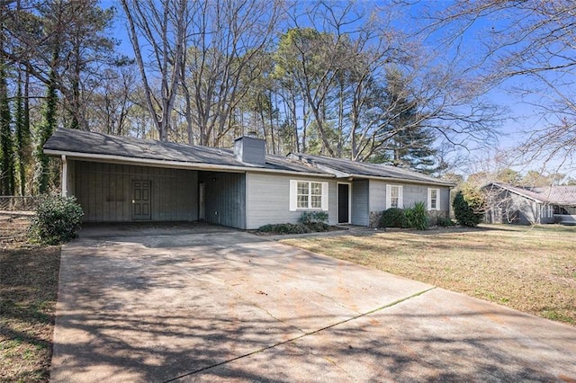 ranch-style home with a front yard, driveway, and a chimney