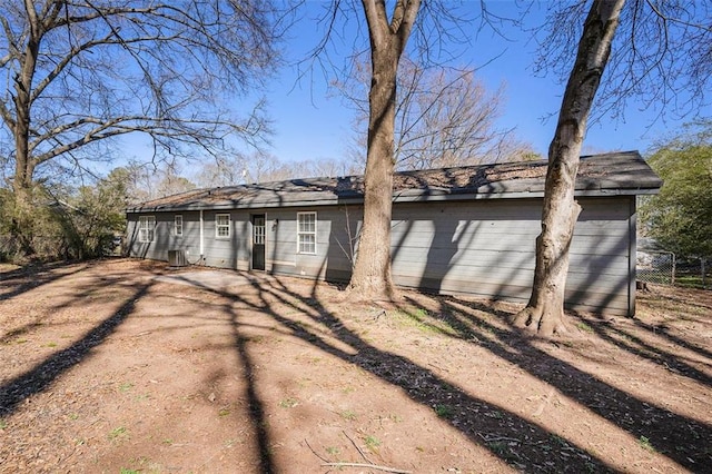 back of house featuring central AC and fence