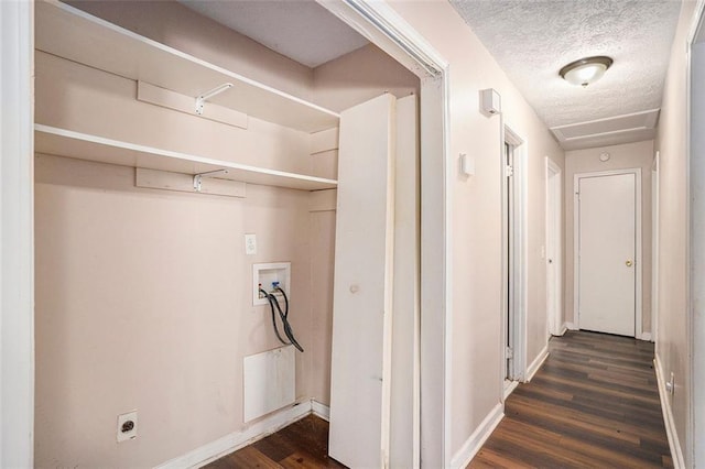 laundry area with laundry area, baseboards, dark wood-style floors, a textured ceiling, and washer hookup