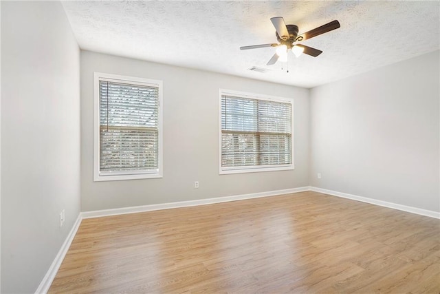 unfurnished room with a healthy amount of sunlight, light wood finished floors, and baseboards