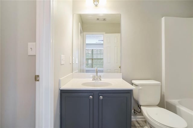 bathroom featuring a washtub, visible vents, vanity, and toilet