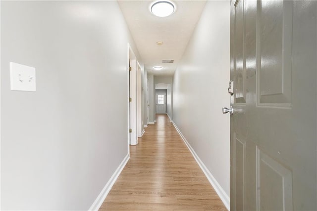 hall featuring baseboards and light wood-style floors