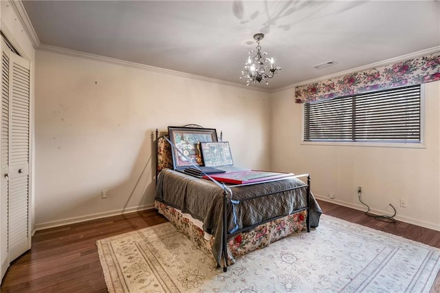 bedroom featuring visible vents, a notable chandelier, wood finished floors, crown molding, and baseboards