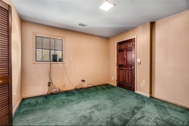 empty room featuring visible vents, baseboards, and carpet