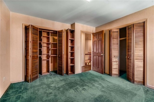 unfurnished bedroom with multiple closets and carpet floors