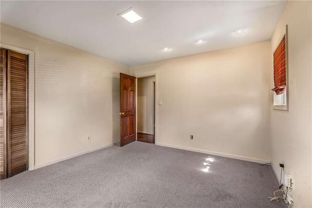 unfurnished room with baseboards and carpet